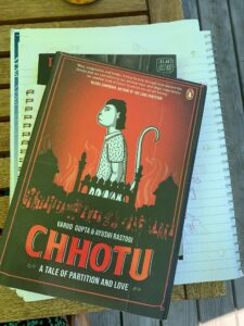 Photo of the book Chhotu: A Tale of Partition and Love by Varud Gupta and Ayushi Rastogi sitting on top of a spiral bound notebook.